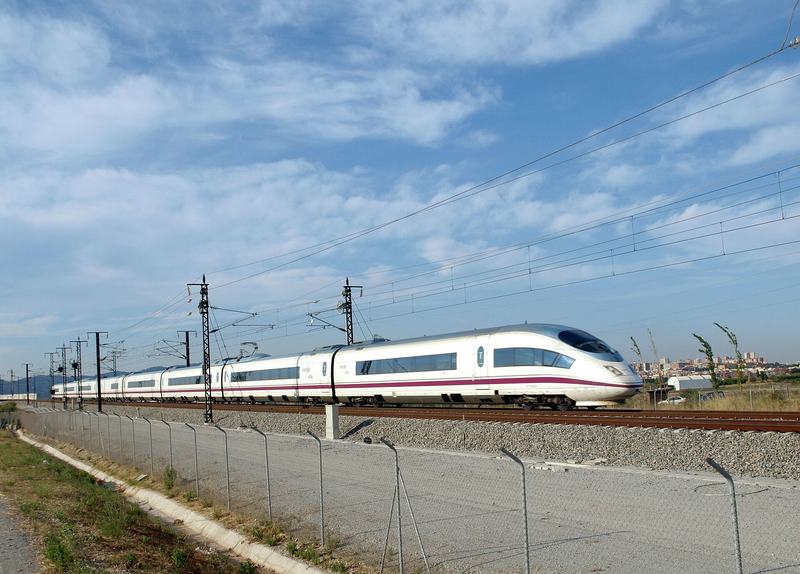 A white Spanish AVE high-speed train running under overhead lines