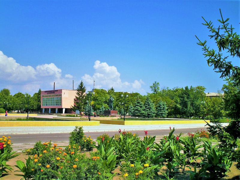 The central square of Oleshky with trees and a building in summer